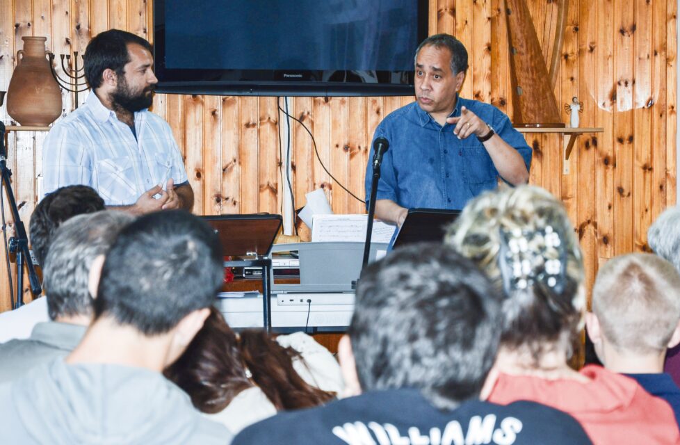 a man stands in front of a group of people at church and preaches