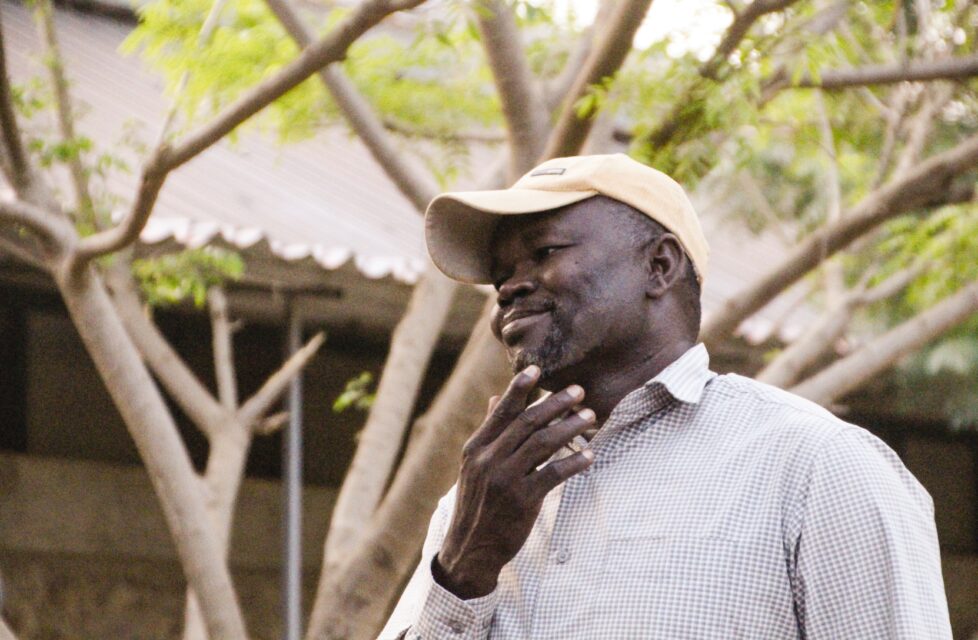 a man stands outside his home smiling